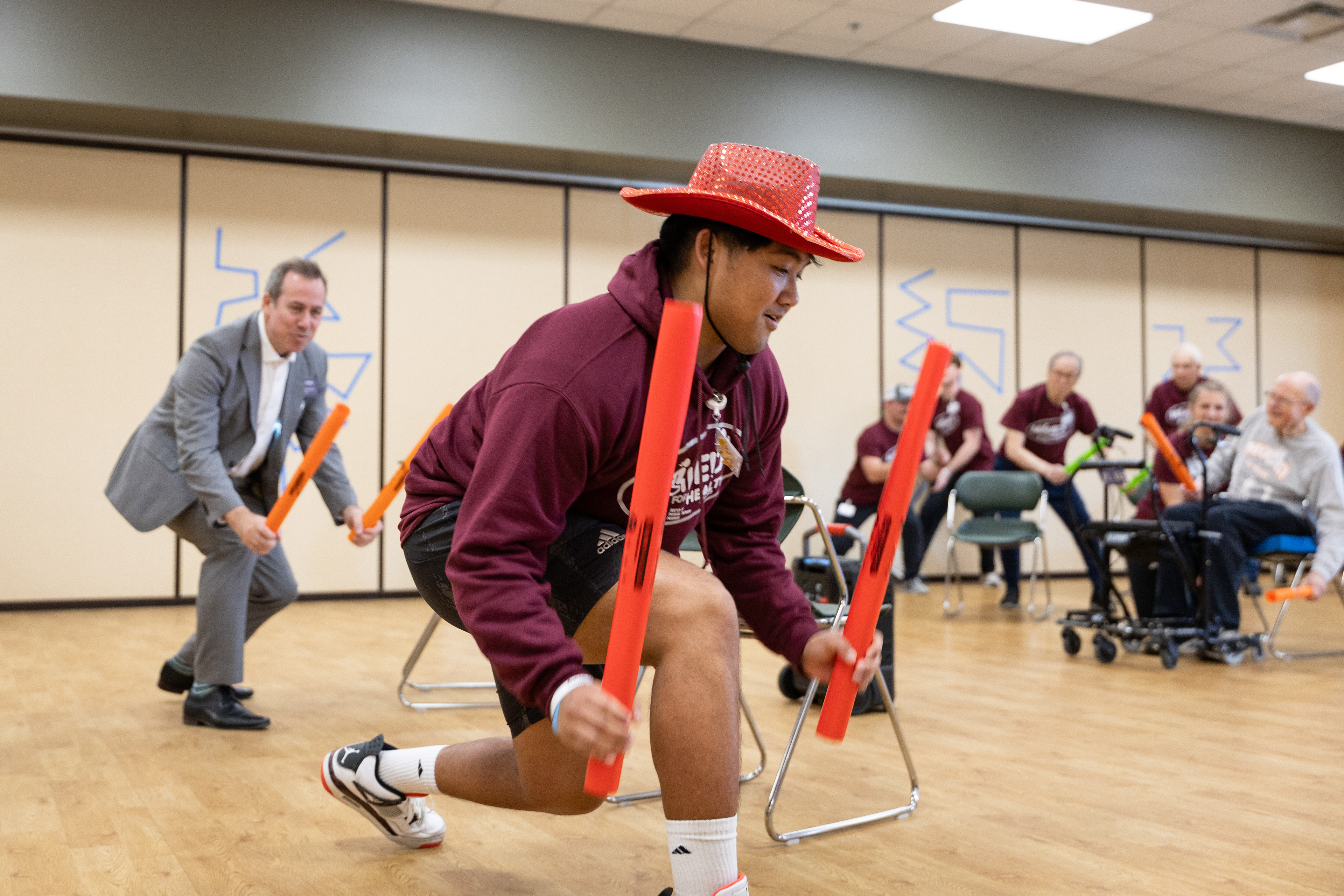 Central Michigan University second-year physical therapy doctoral student Julian Tenerife, right, leads the MOVE! For Health class warm-up with CMU 16th President Neil MacKinnon, left, at the Commission on Aging, 2200 S. Lincoln Rd., Mount Pleasant, Michigan, Thursday, March 20, 2025.