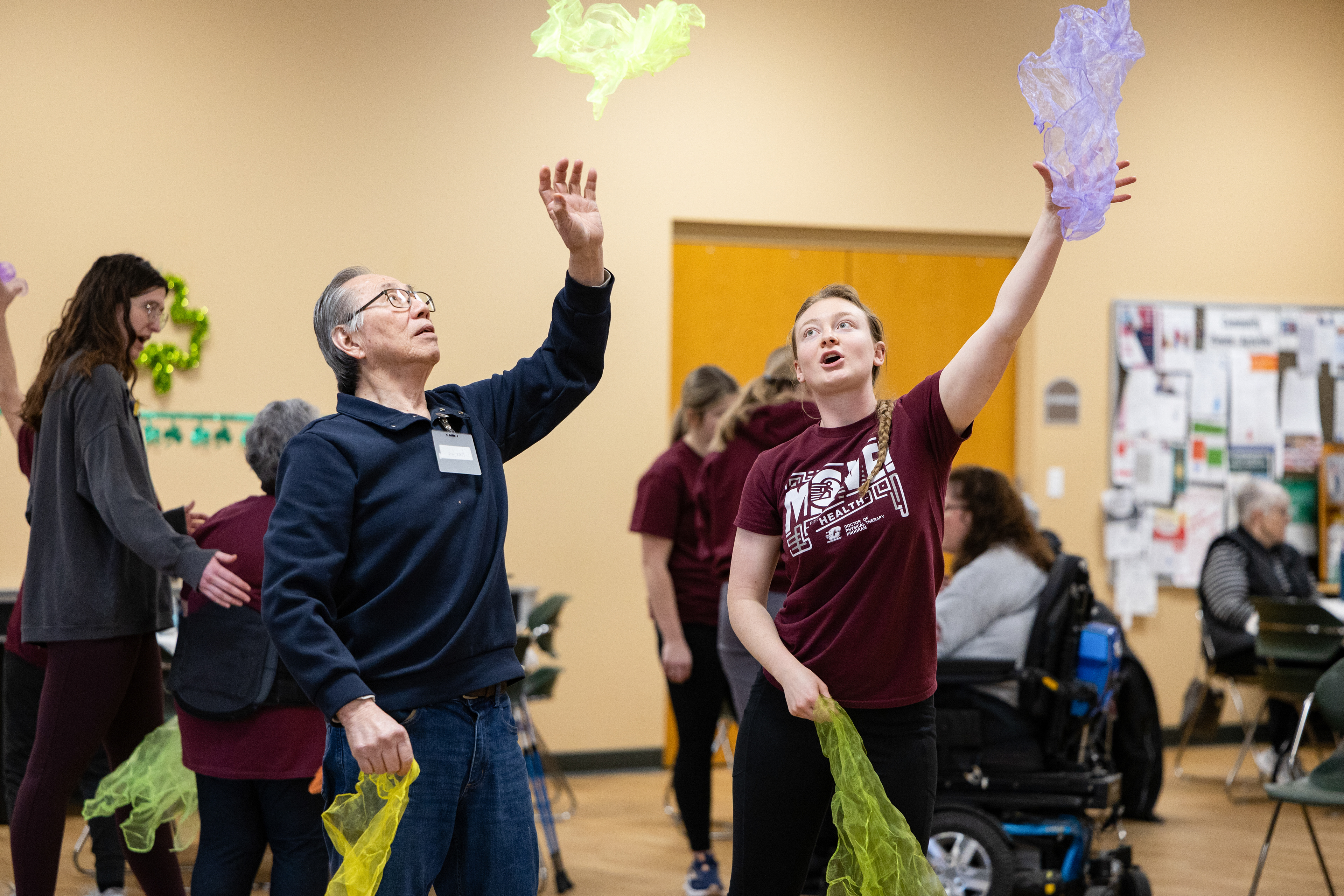 Central Michigan University second-year doctoral student Kabryni Bruening, right, throws a scarf up with participant Charles, left, during a MOVE! For Health class at the Commission on Aging, 2200 S. Lincoln Rd., Mount Pleasant, Michigan, Thursday, Feb. 27, 2025.