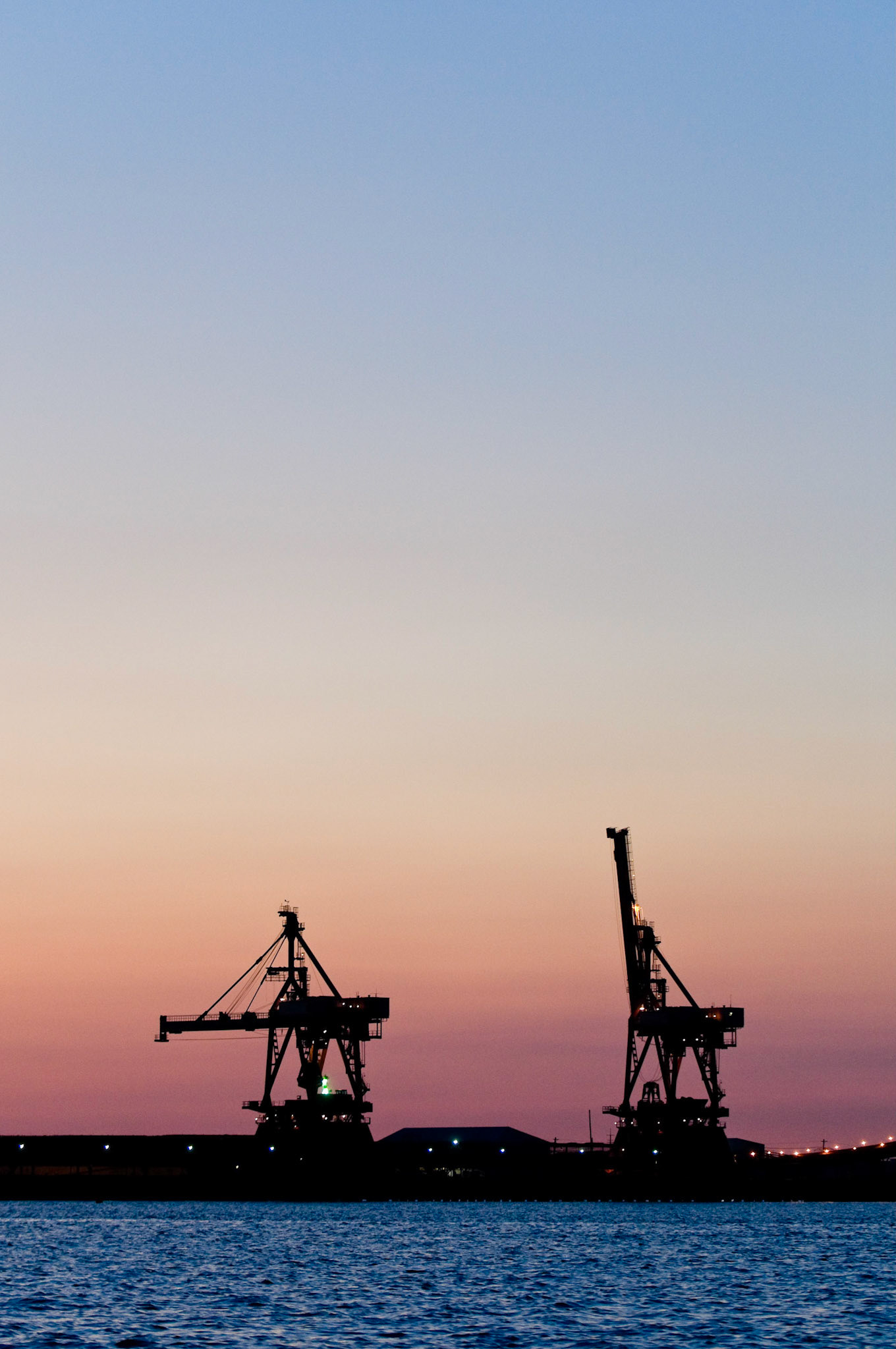 Cargo cranes at Bethlehem Steel silhouetted against a sunset sky