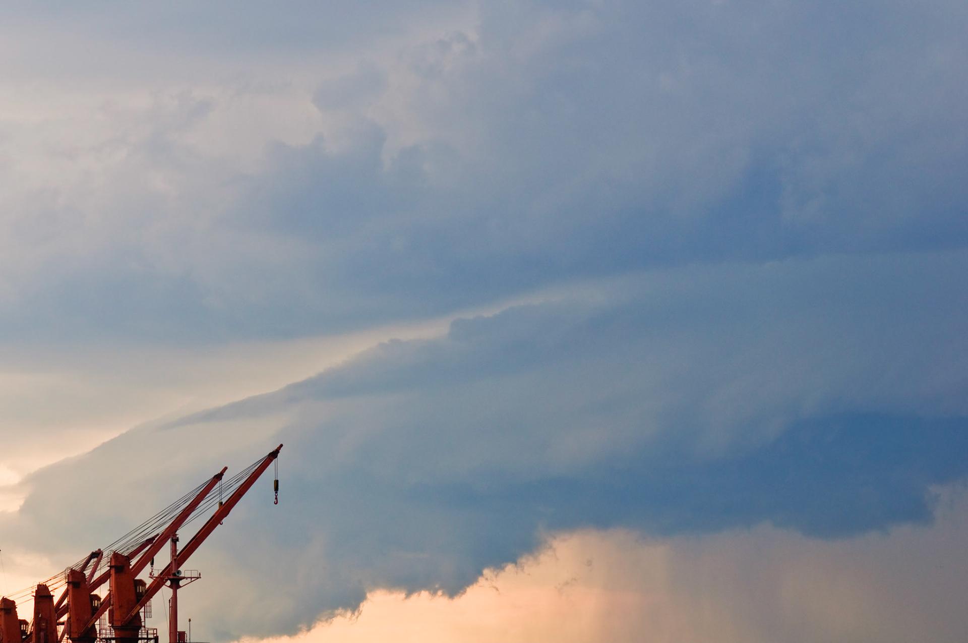 Deck cranes of the cargo ship "Lucky Transporter" under the dark clouds of summer storm