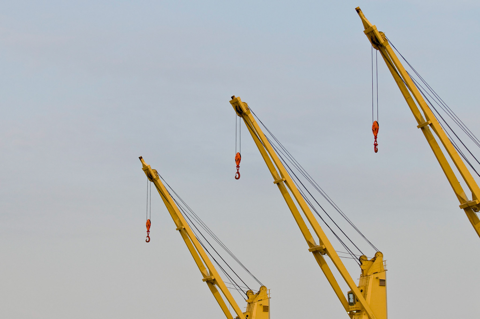 Deck cranes of a cargo ship docked at Domino Sugar