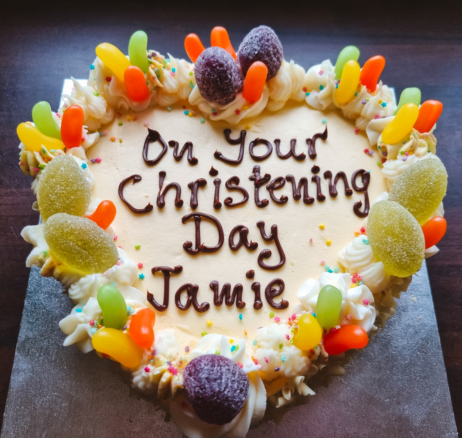 Christening cream and fruit cake with writing on top