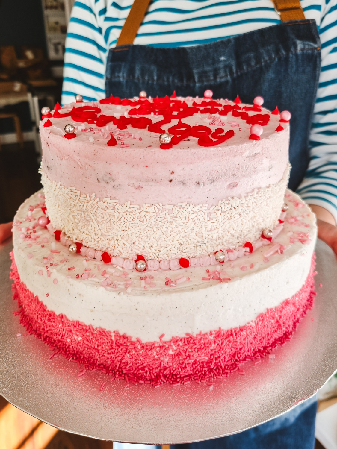Two tier Christening buttercream cake in pink with red writing,