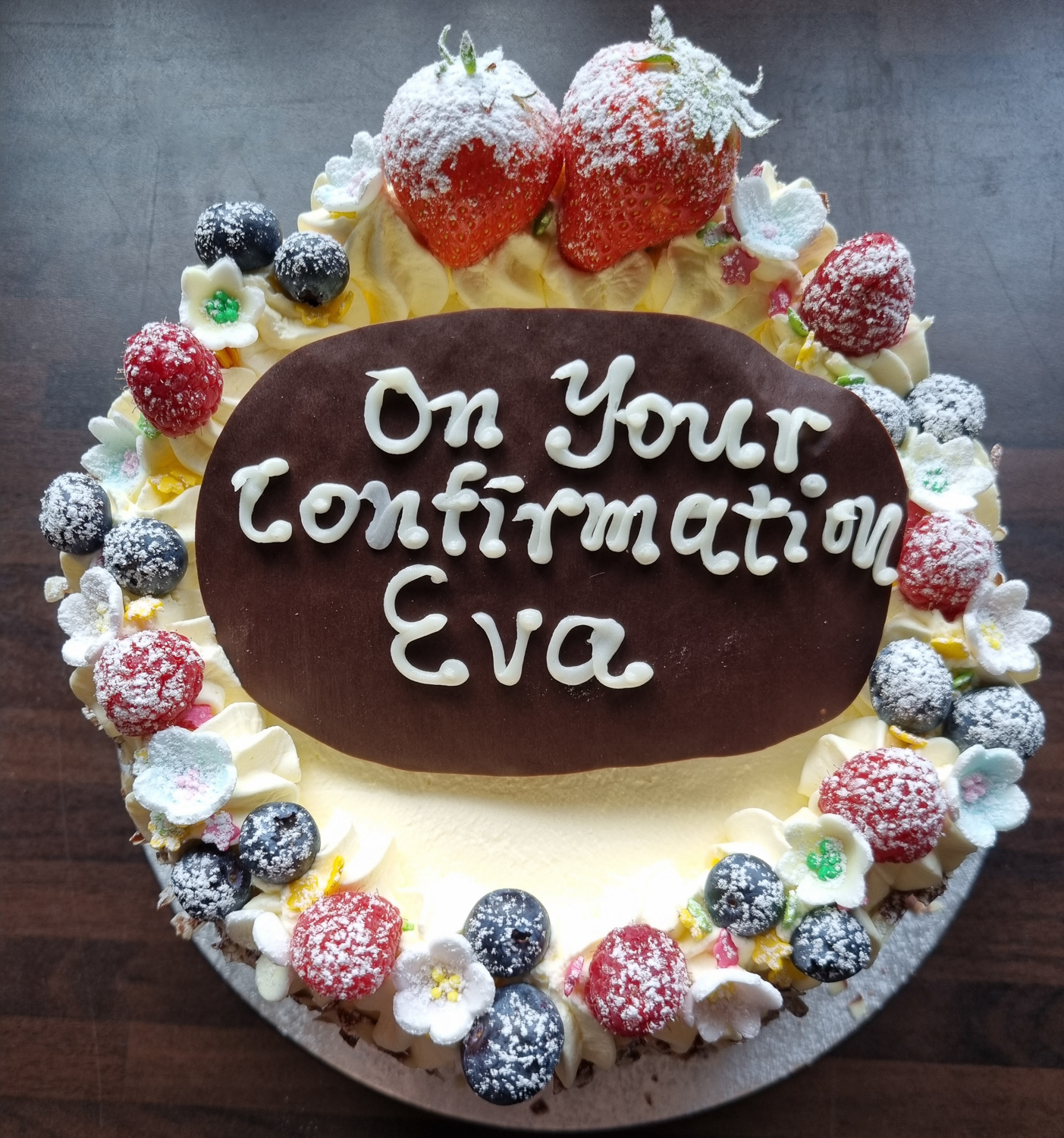Cream and Strawberries Confirmation cake with message written on chocolate slab