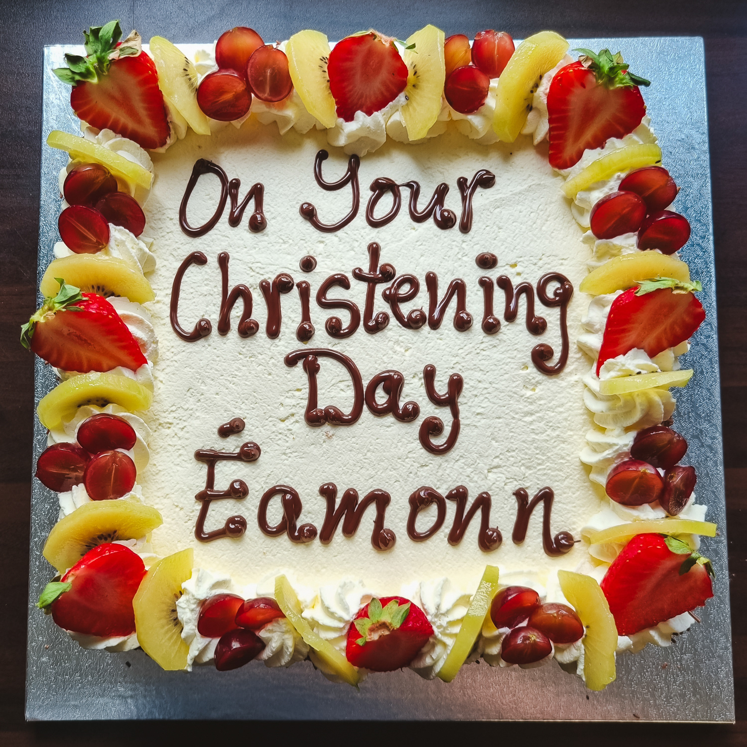 Christening Cream cake with mixed fruit and writing on top