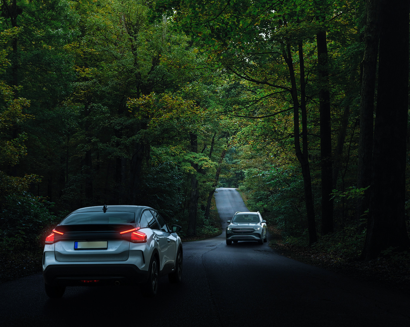 Turn on the taillights of the silver crossover SUV with a bright red illumination.