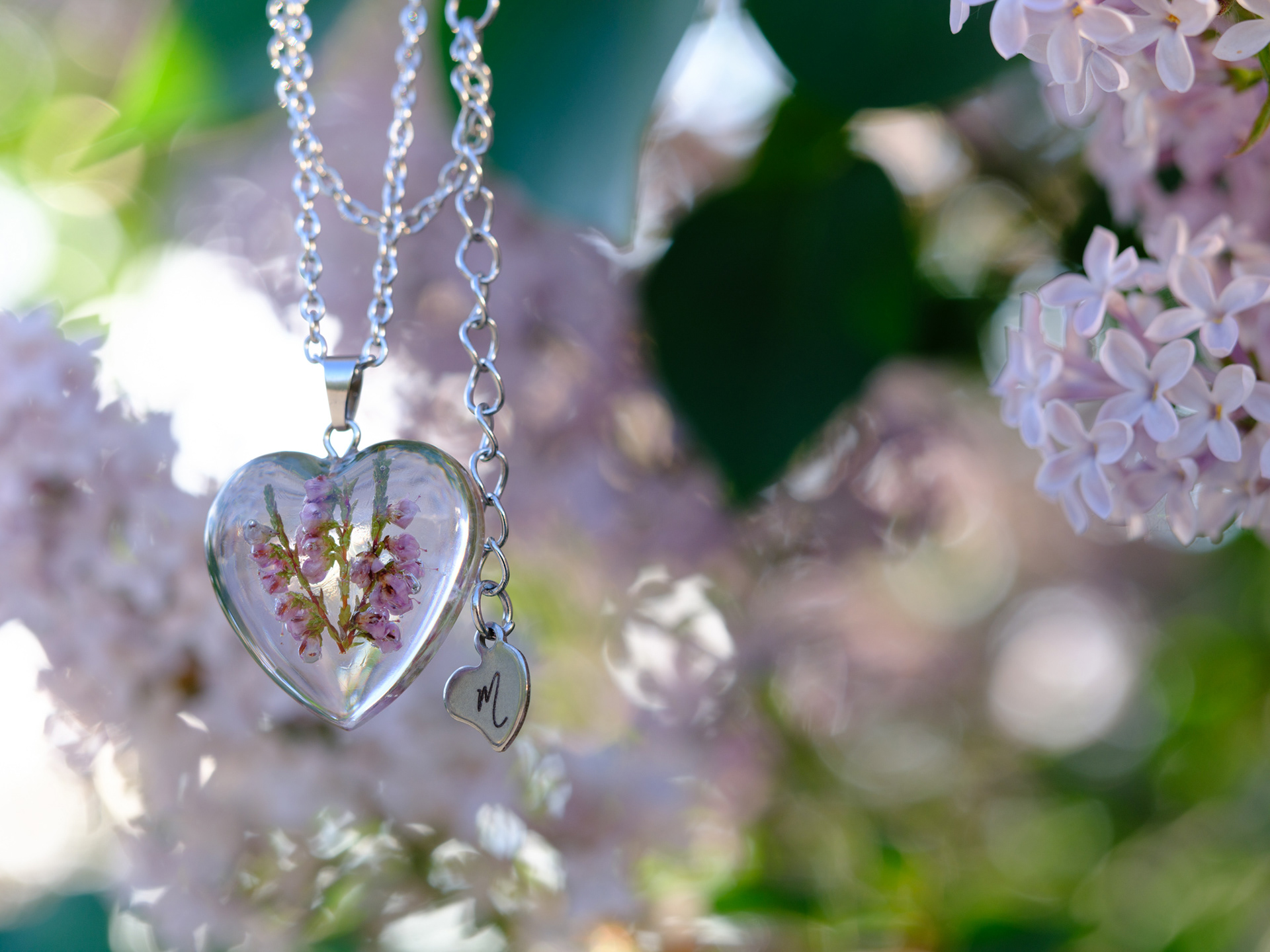 Gorgeous flower and resin necklace photographed in a lilic bush