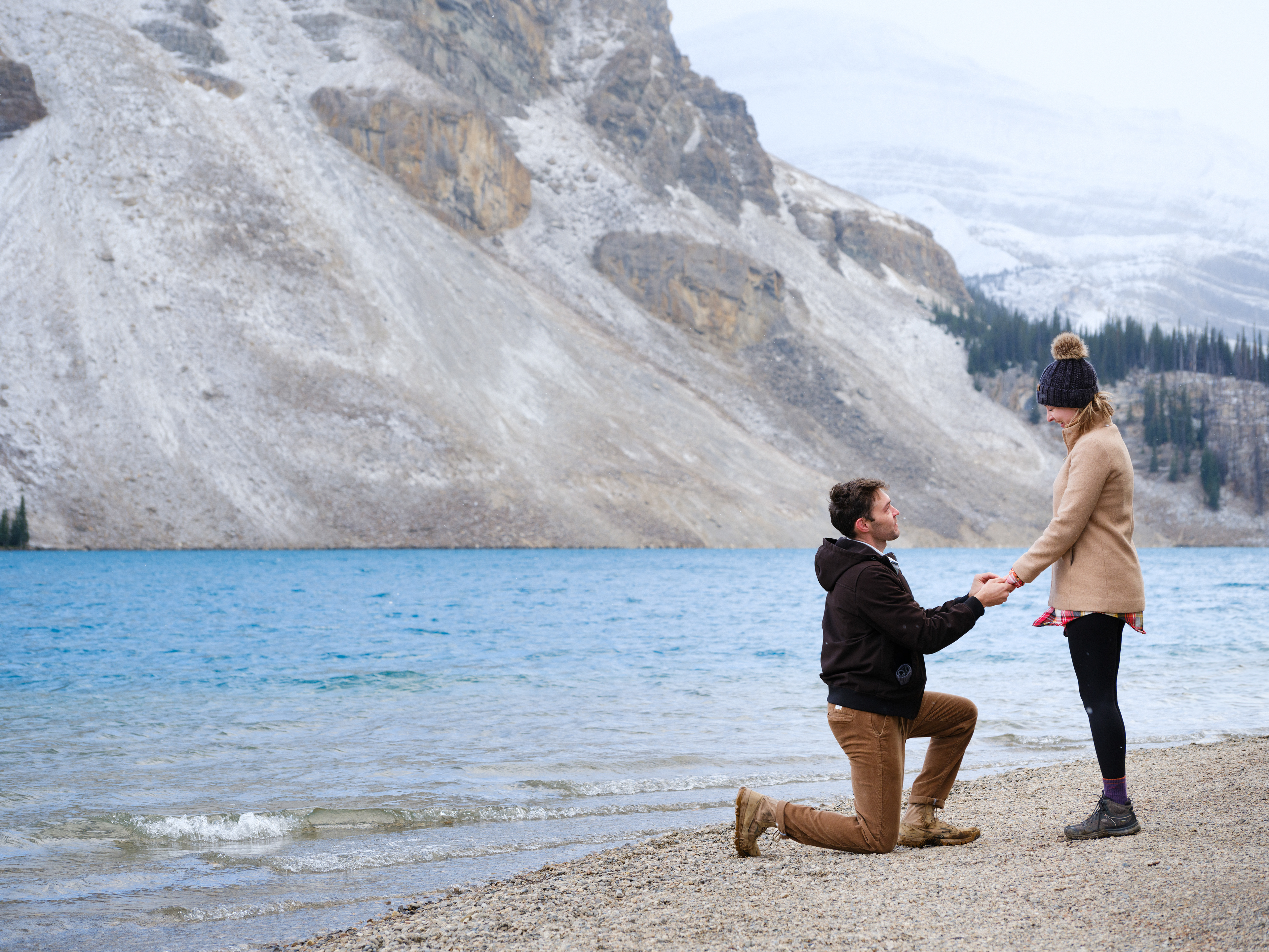 Man proposing in the Canadian Rockies at a beautiful lake with huge mountains