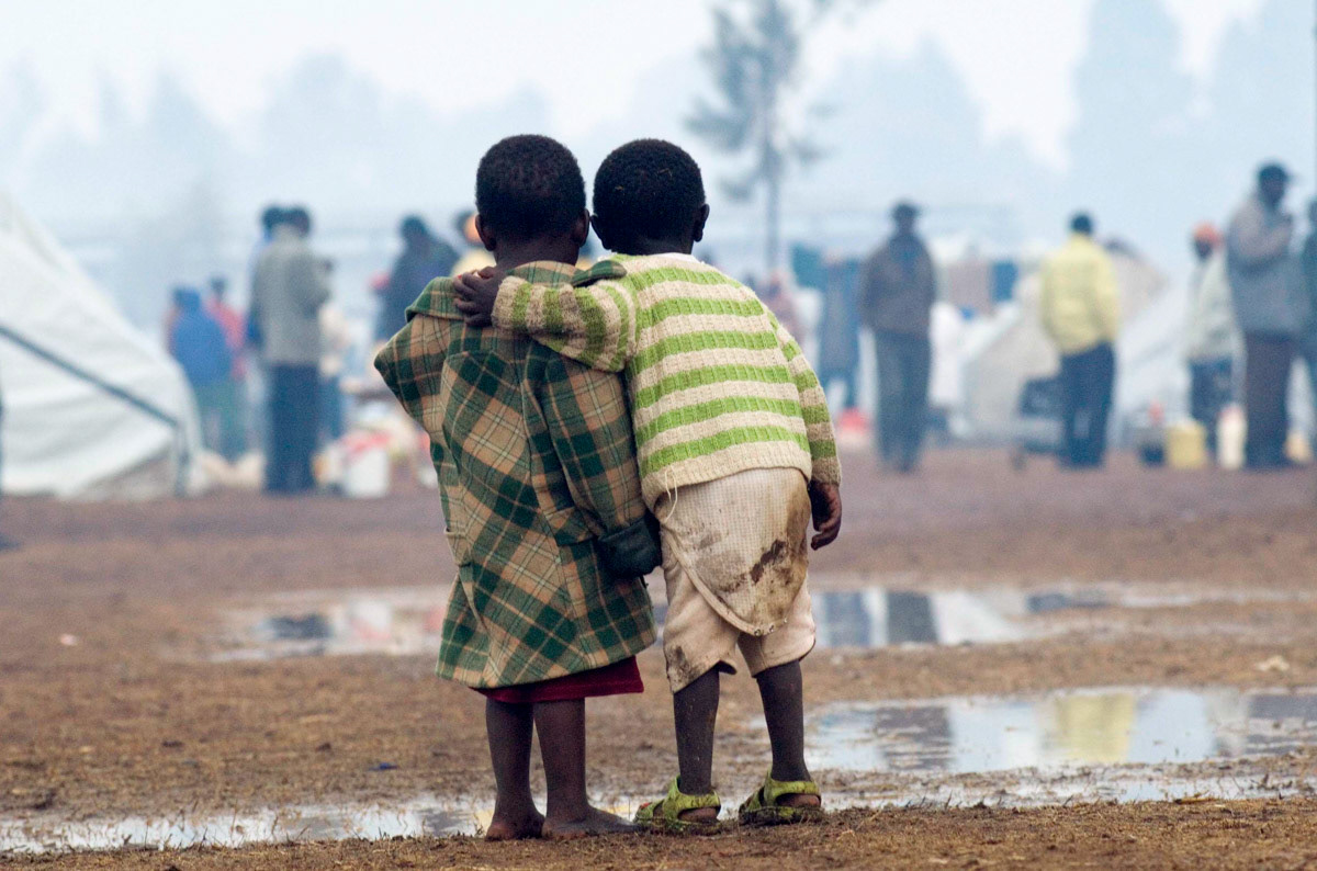 Two children stand together as heavy rain falls in a camp of over 18,000 people displaced by post election violence in Kenya's Rift Valley. Feburary, 2008.
