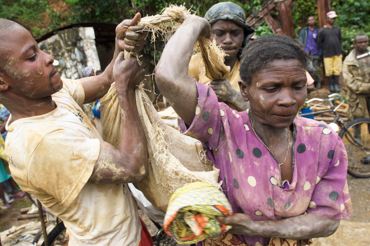 Nobikana Mary, 43, hoists up to 50 kgs of rocks on to her back with the help of two men. Her husband has TB and is very weak. They have nine children. "There is no-one else to help me."