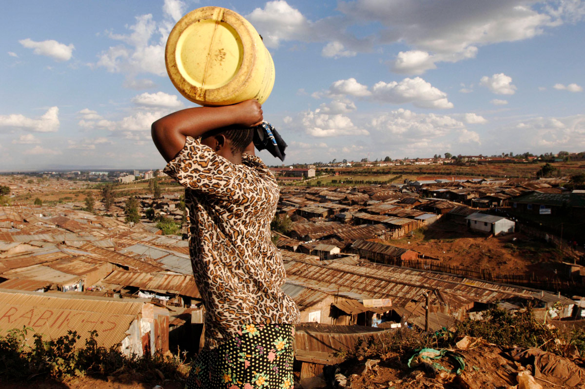 A woman carries water along Kenya's railway line which runs through Kibera slum, in Nairobi, one of the largest slums in Africa.