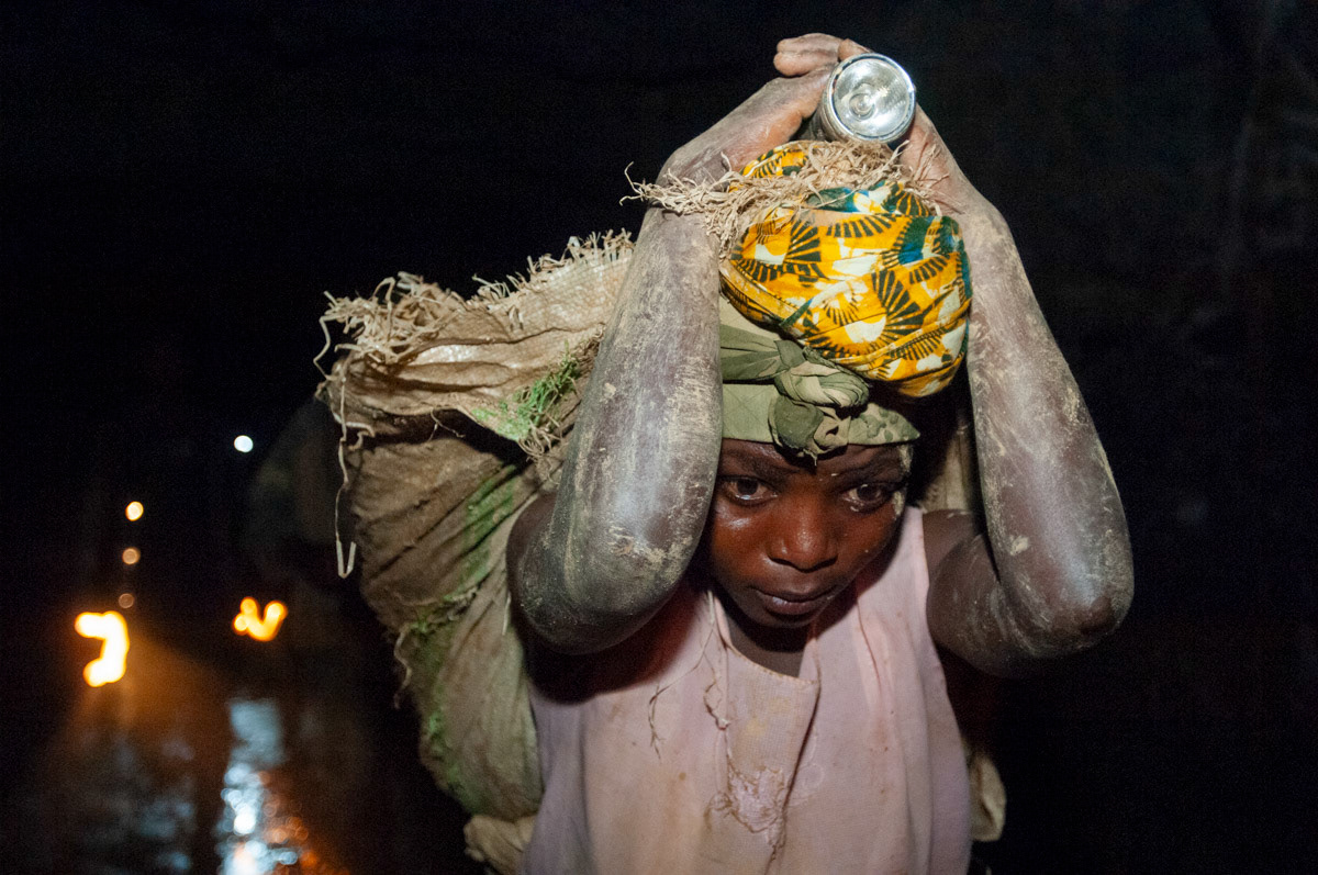 young girl carries up to 40 kgs of rocks, on her back, out of Adidi gold mine in north eastern Congo. (See STORIES for the full feature)