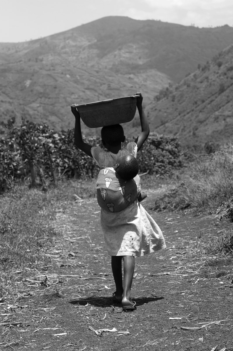 A young girl travels far through the rural countryside in the Democratic Republic of Congo to collect water. The area is remote and the risk of attack is high.