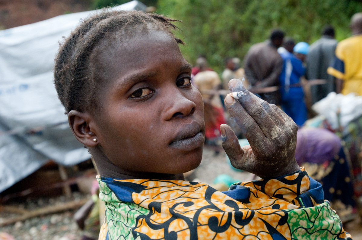 A woman waits outside of Adidi mine in the hope of work collecting rocks from inside. There is an increasing amount of competition for work as more women arrive in search of work.