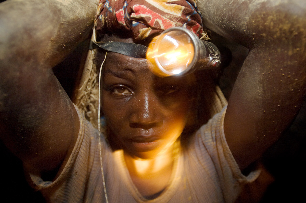 A young girl carries around 40kgs of rocks out of Adidi gold mine.