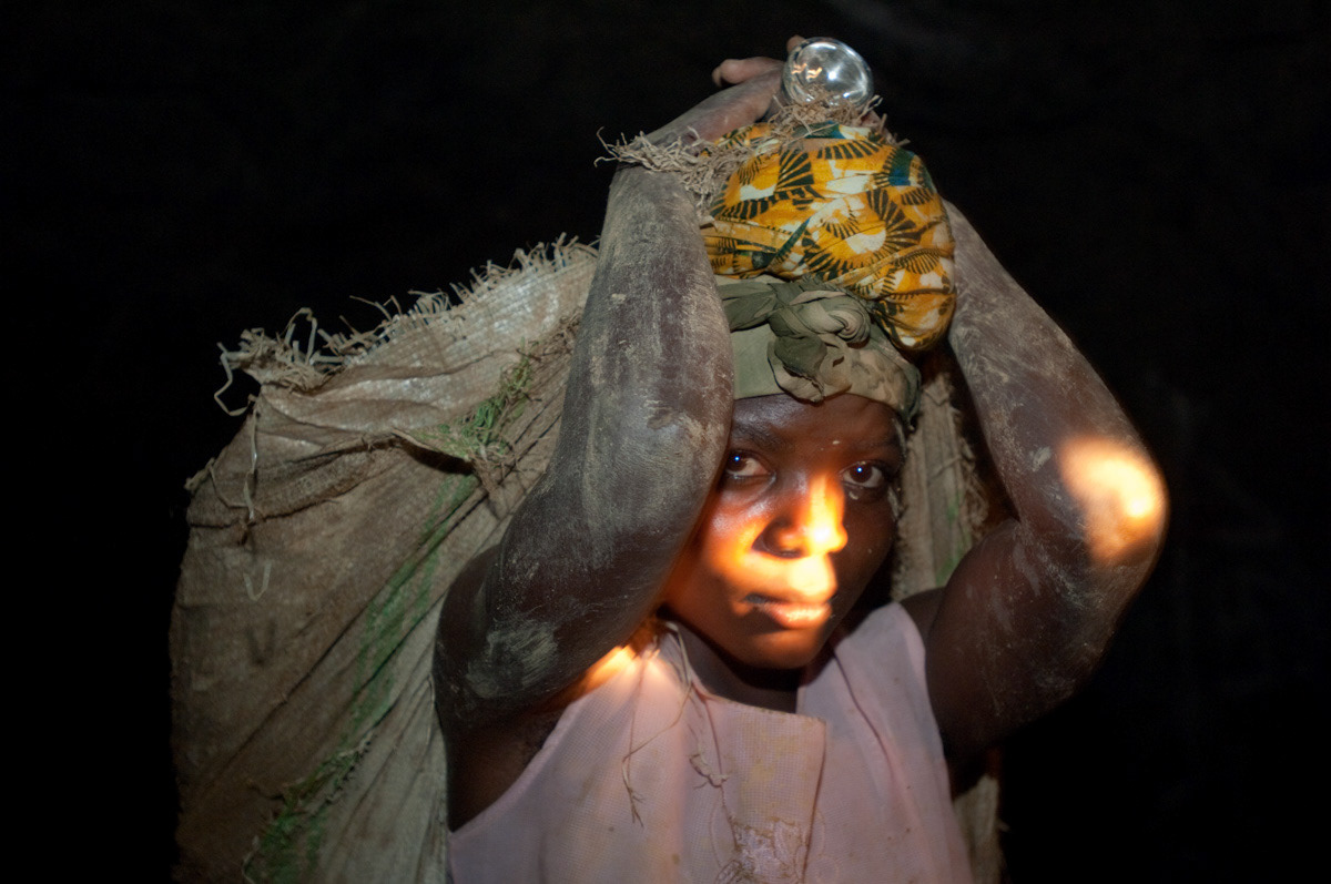 A young girl carries up to 40 kgs of rocks, on her back, out of Adidi mine in north eastern Congo.