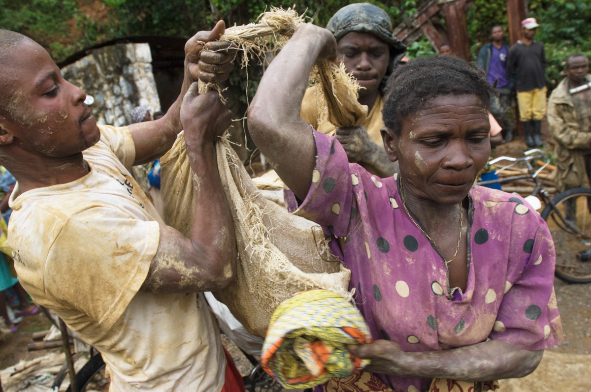Nobikana Mary, 43, hoists up to 50 kgs of rocks onto her back with the help of two men. Her husband has TB and is very weak. They have nine children. “There is no one else to help me." Adidi mine, North Eastern Democratic Republic of Congo. (See STORIES for the full feature)