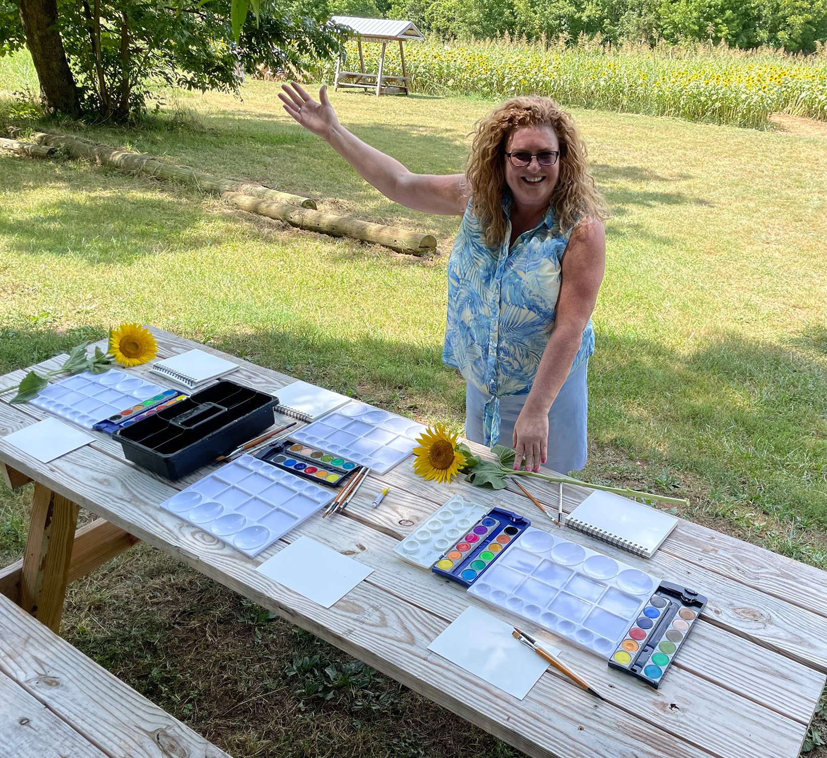 Kathleen setting up watercolors for a Paint Your Sunflower station.