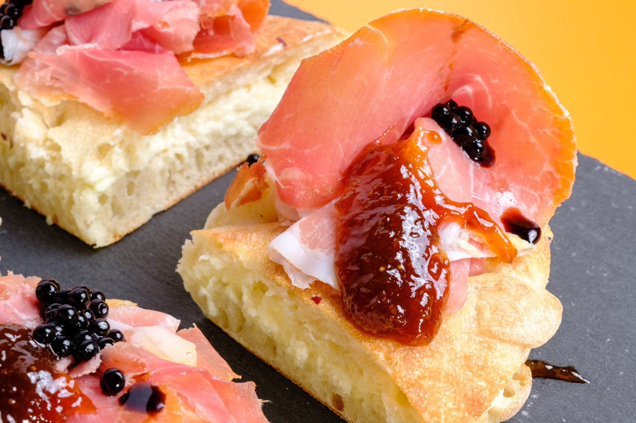 Panino croccante con prosciutto crudo e mostarda di fichi e perline di aceto balsamico