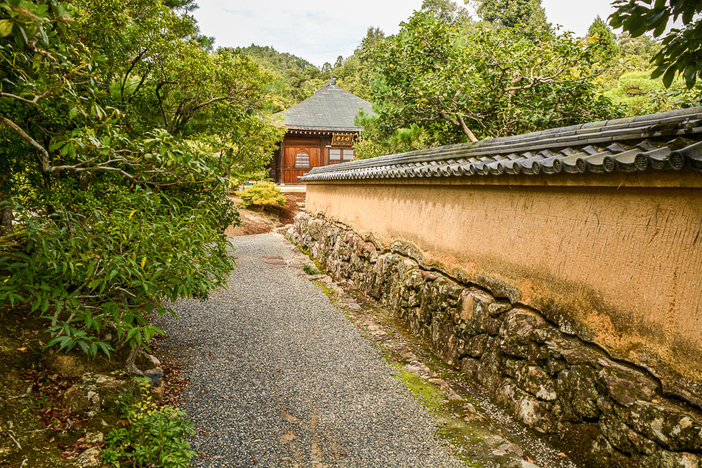 A pathway leads to a building nestled in the gardens.