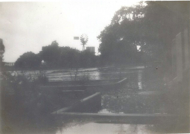 Floodwaters between the main farmhouse and the dairy windmill.