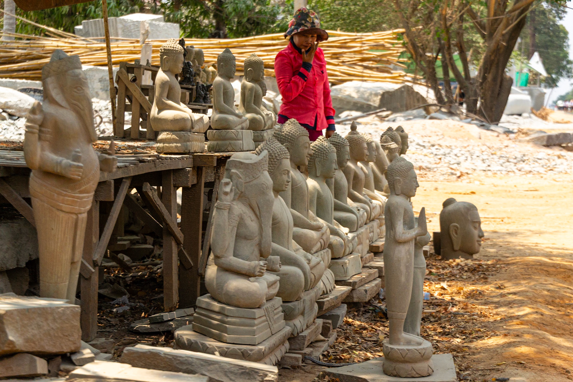 Roadside vendor displaying a range of carved religious busts and statuettes.