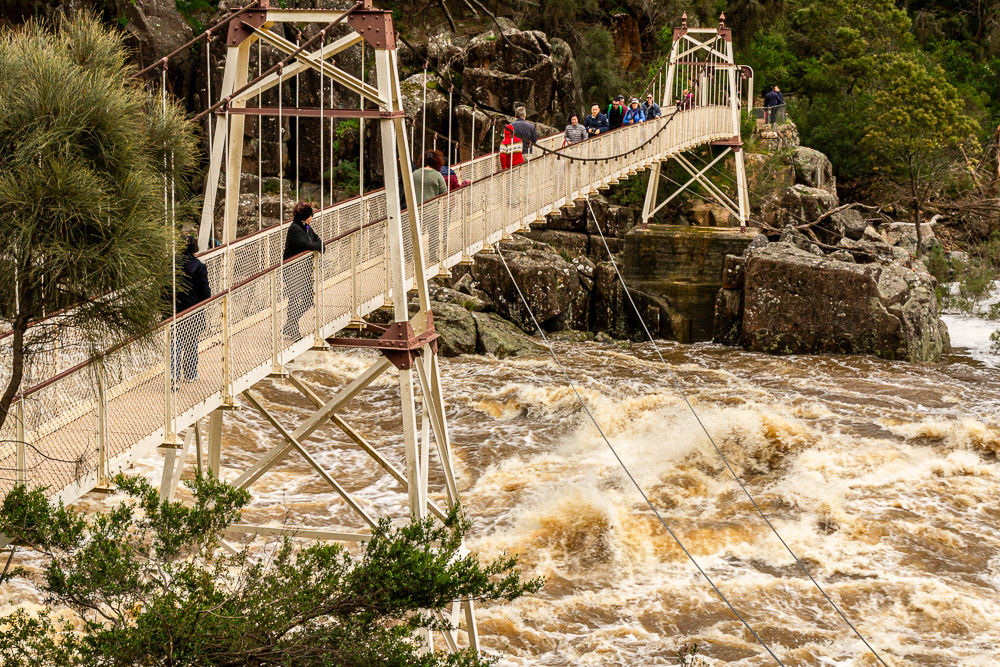 Raging floodwaters surge beneath the Cataract Gorge Suspension Bridge.