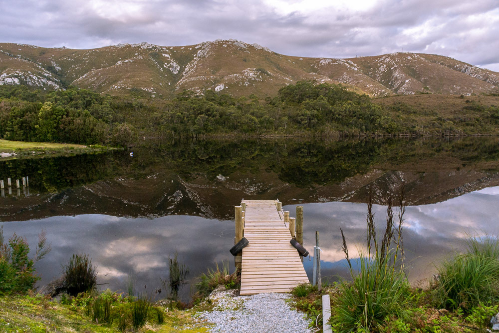 The surrounding hills are perfectly mirrored in the lake surface.