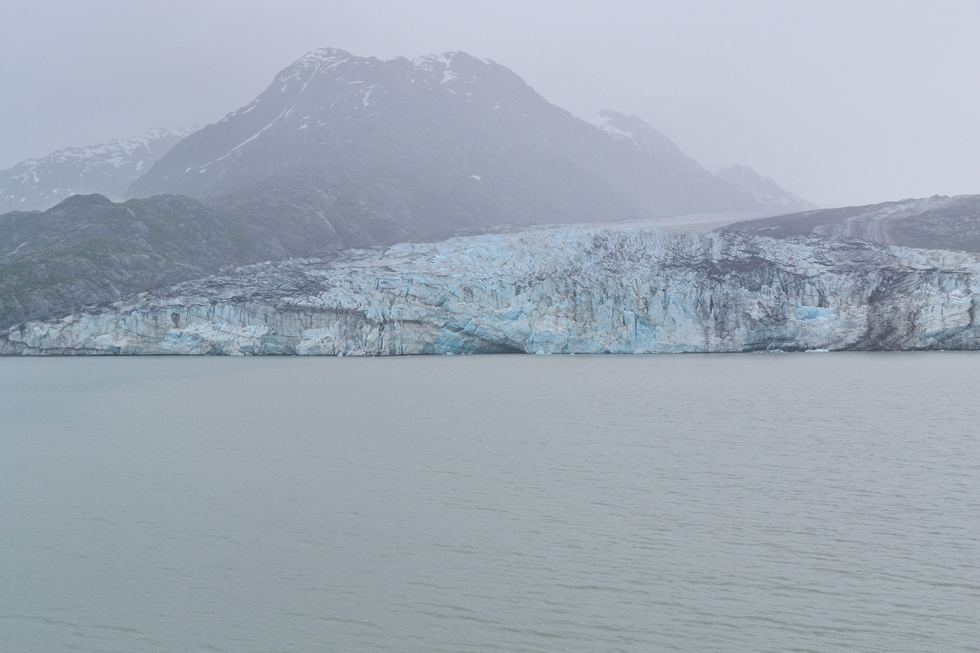 Mountains and mist form eyrie backdrop to the glacier.