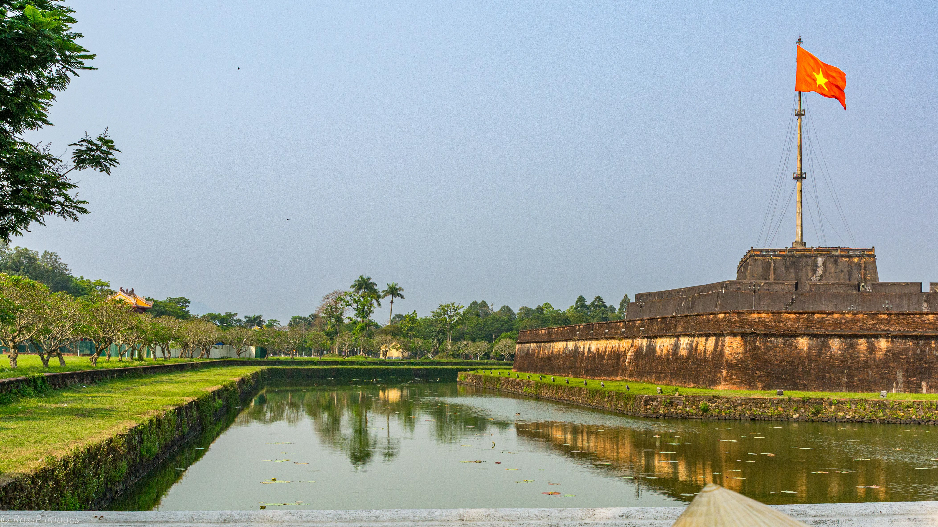 Stage of Flag (Ky Dai) - a huge Vietnamese flag flies over the Imperial City of Hue, located within the citadel walls and moat.