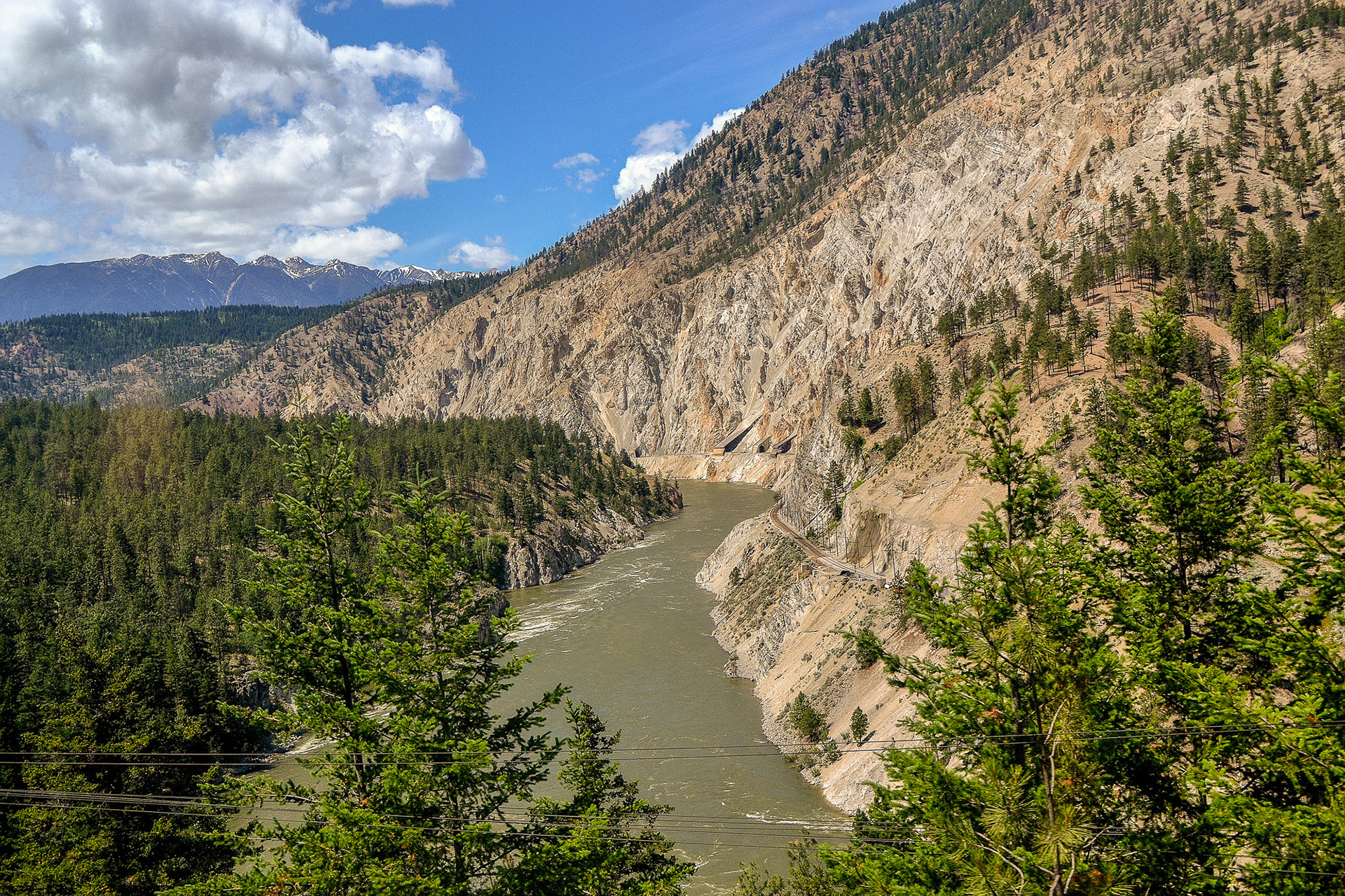 The train tracks carved into the rugged rockface of the mountains as they track alongside the Fraser River.