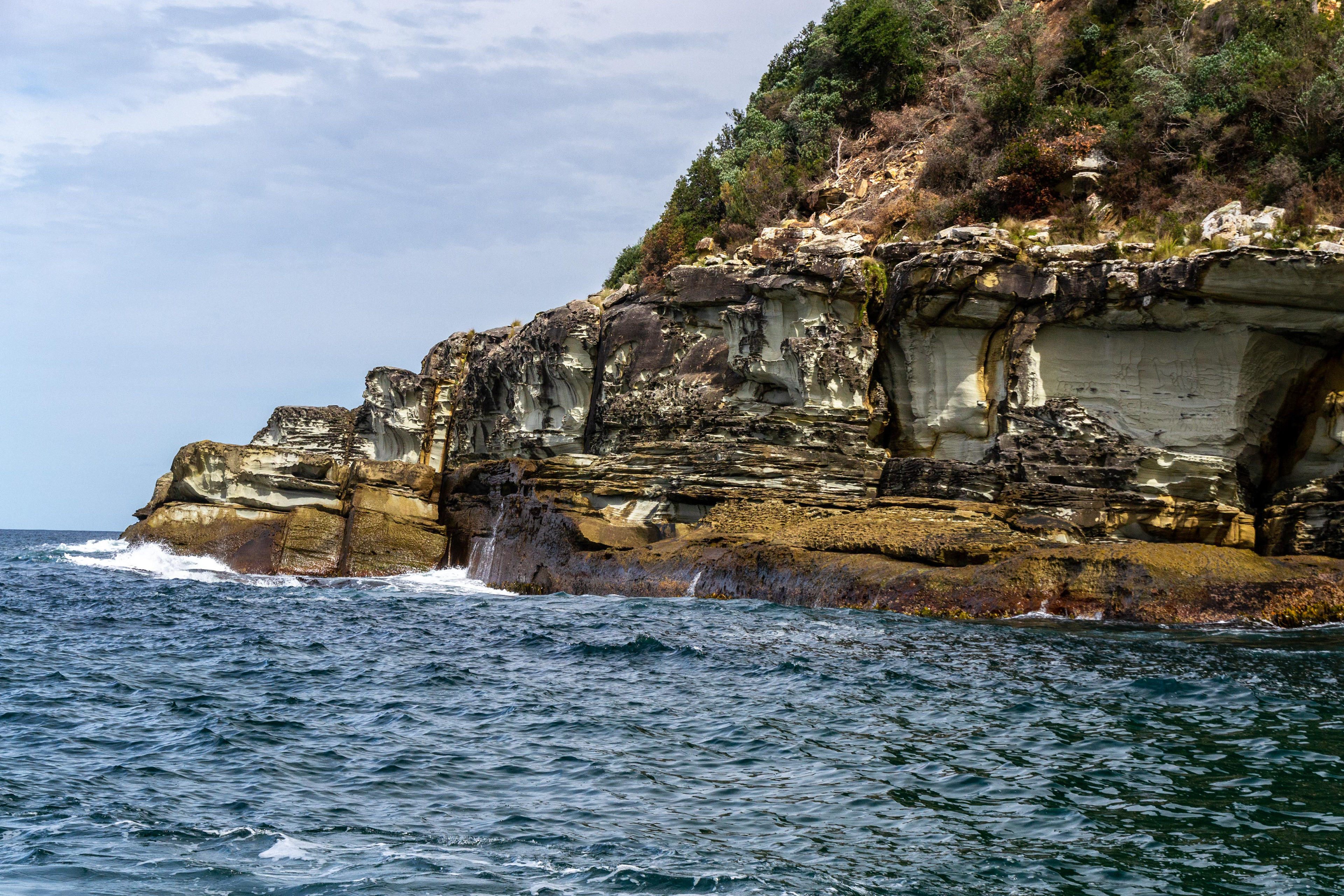 Weathered sandstone erodes to produce different textures and colours to the shoreline.