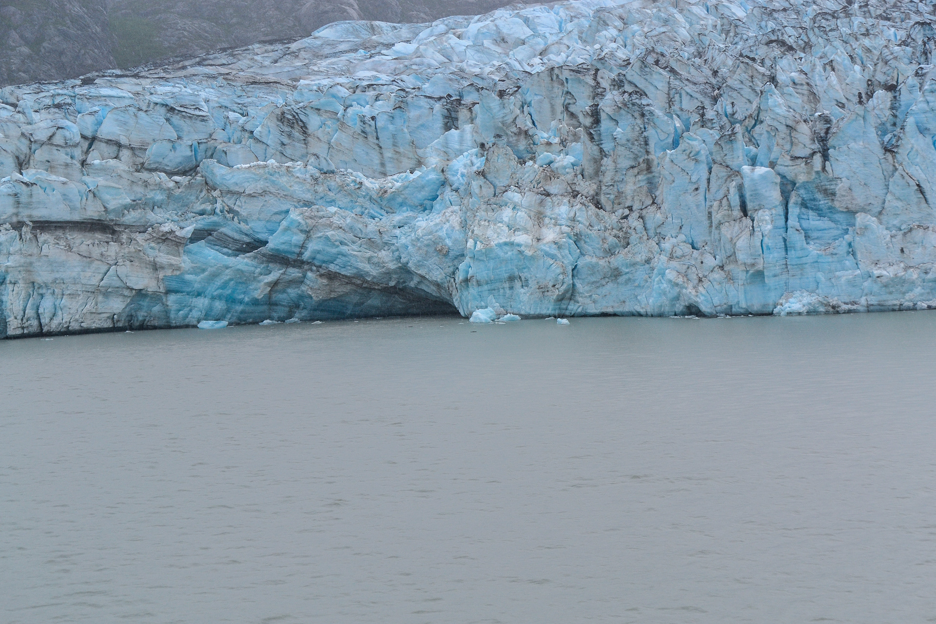 An ice cave accentuates the many colours in the ice of the glacial face.