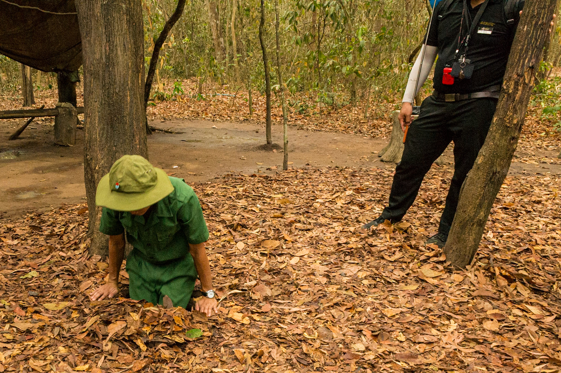 A local Vietnamese ranger demonstrates access to the Cu Chi tunnels......Going, going....