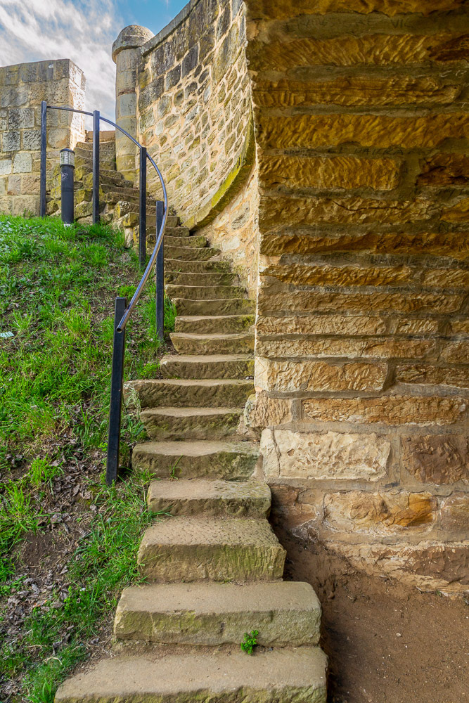 Time-worn sandstone treads lead to the road above.