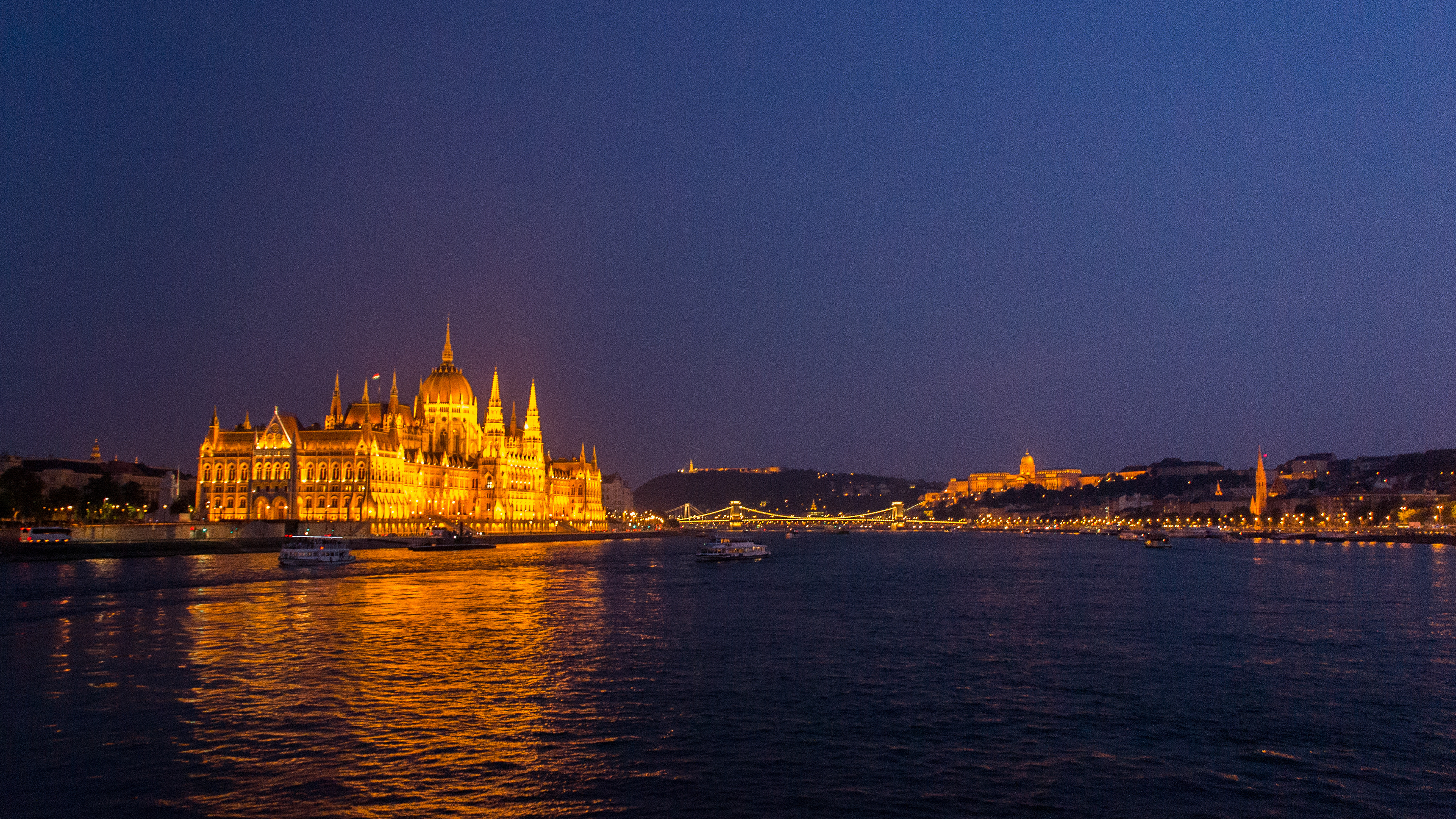 Budapest by night - Parliment House in the foreground with Buda Castle in the background seemingly linked by the Chain Bridge.
