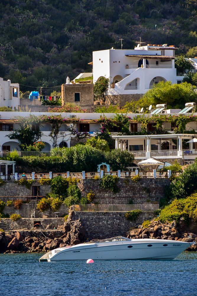 Island-hopping runabout in front of luxury villas.