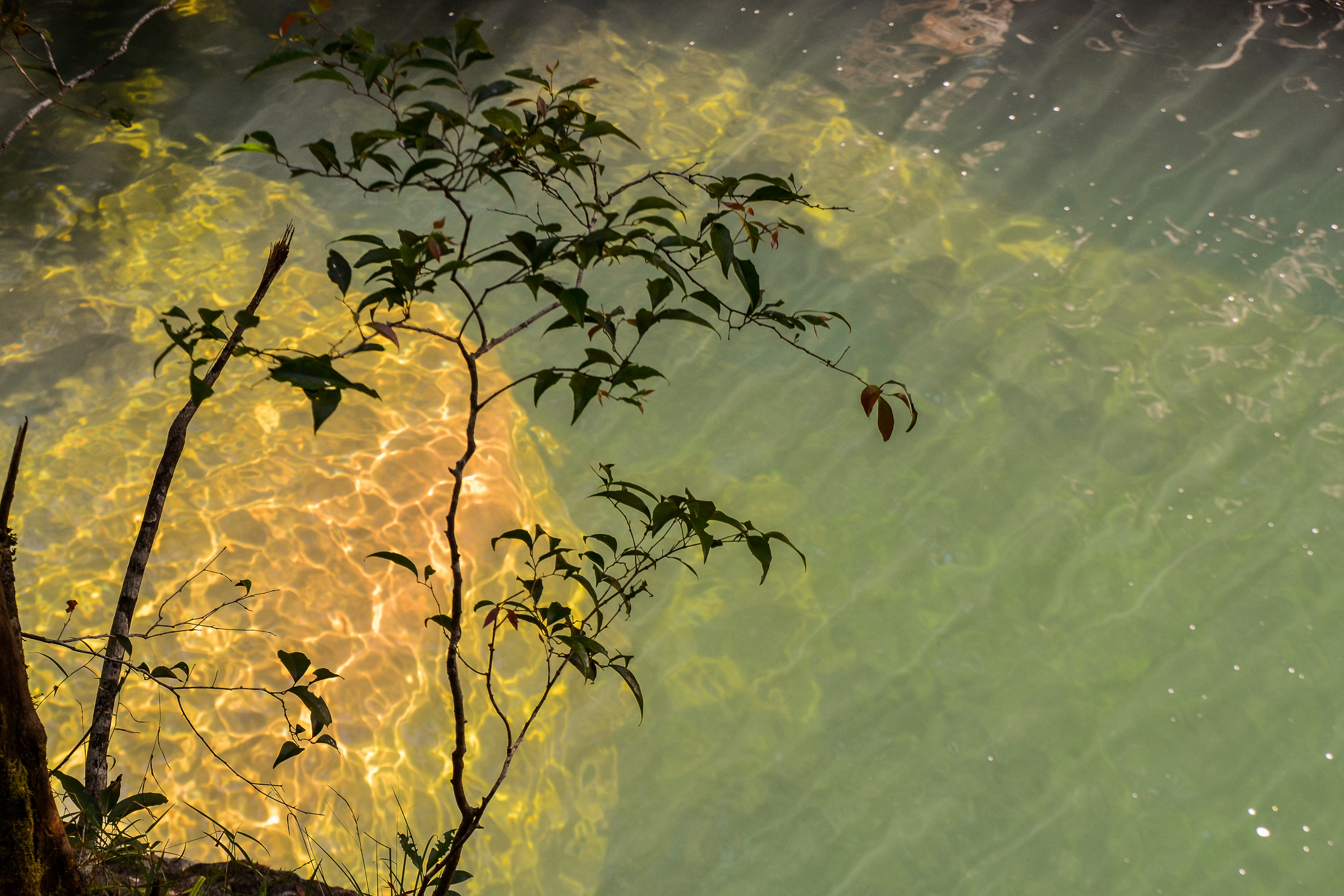 Filtered light patterns dance on the rocks below.