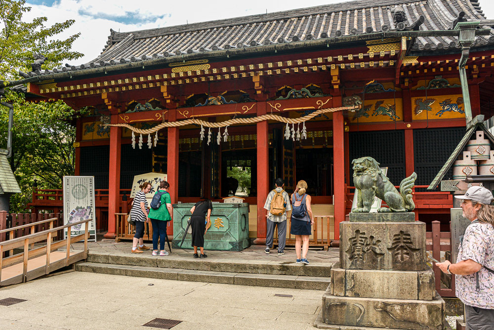 Our guide, Mayumi gives an offering at the shrine. The shrine is one ne of the only two buildings in the area to survive WWII.