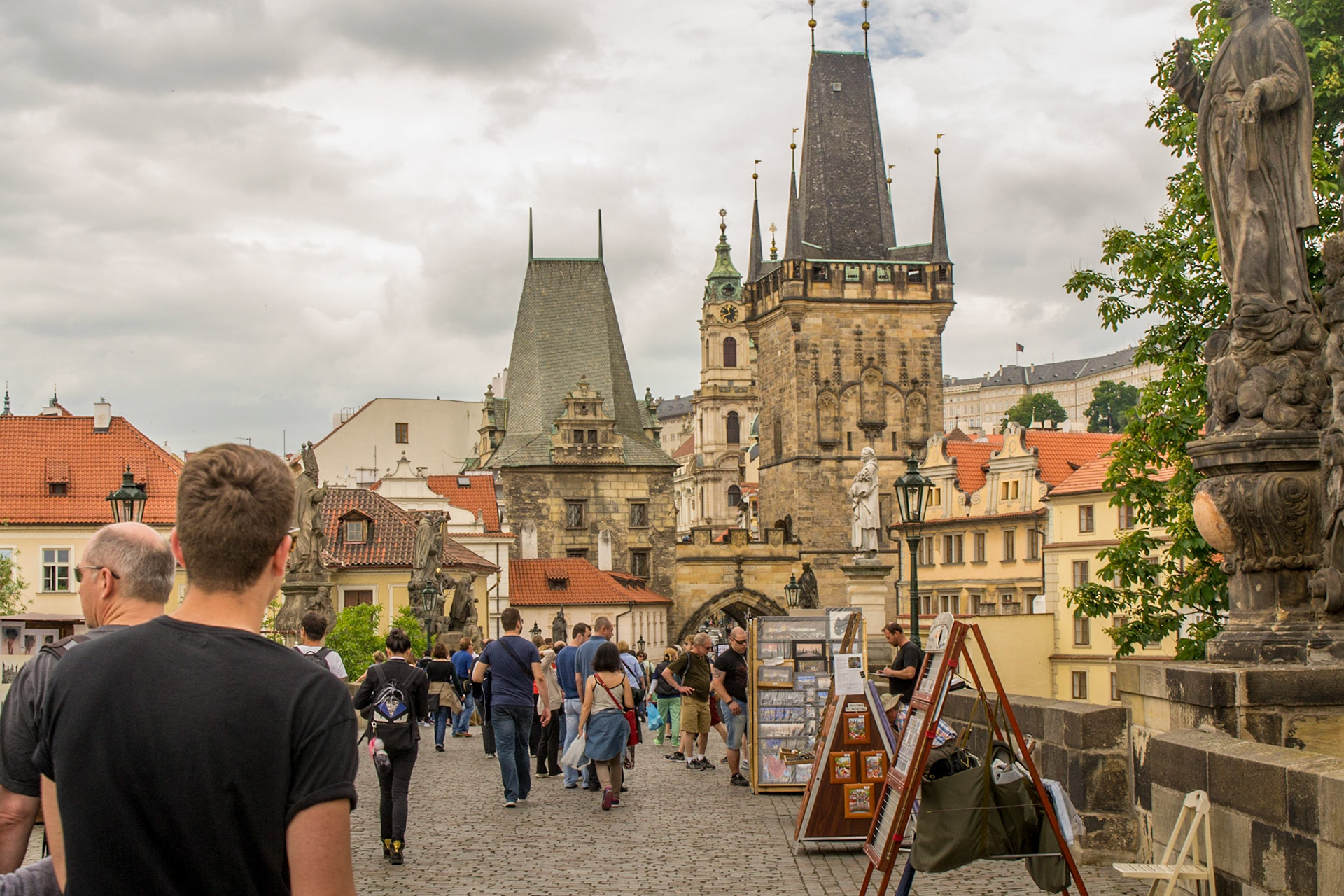Charles bridge now a pedestrian mall occupied by tourists and artisan stalls.
