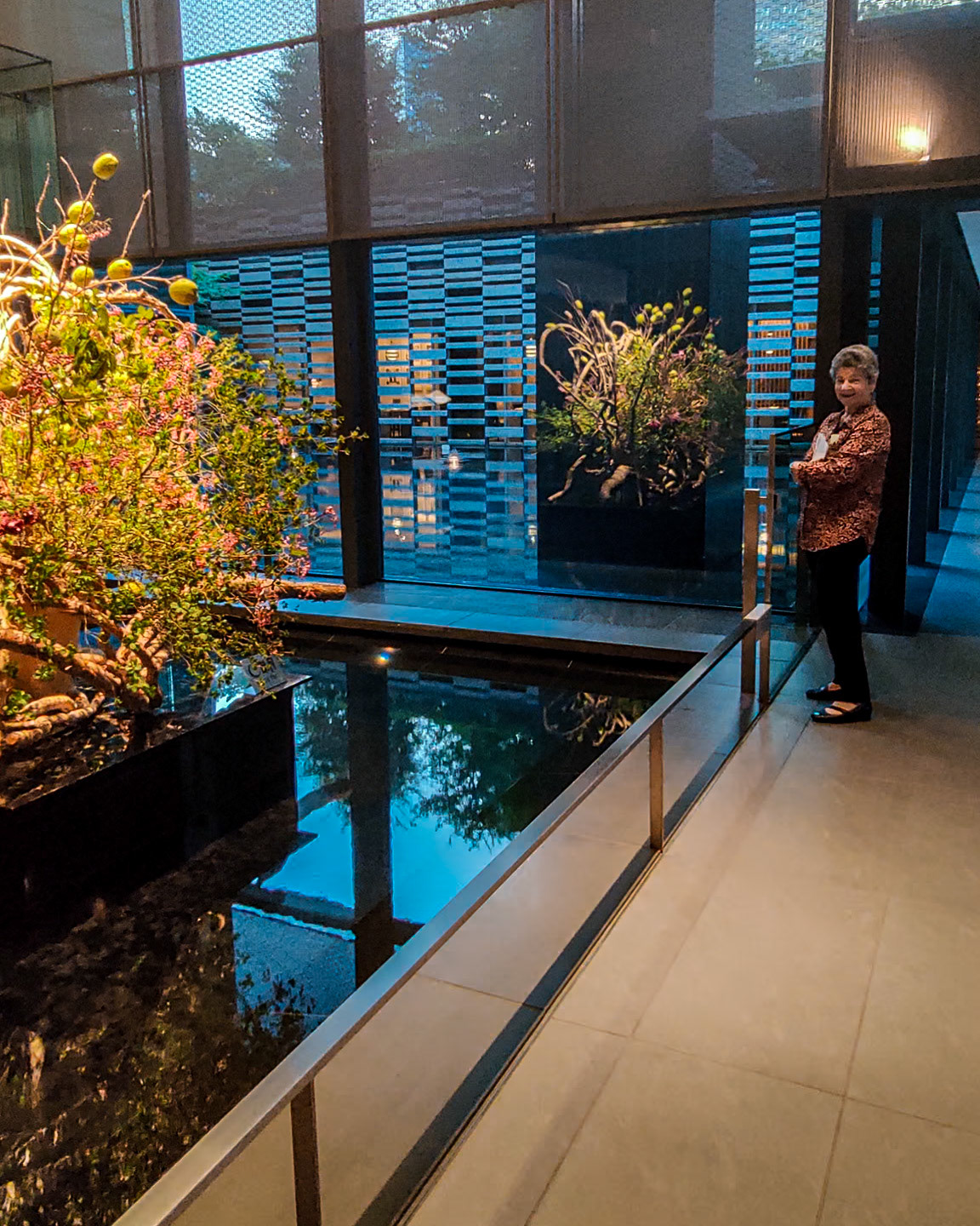 Cheryl admires the entrance foyer's impressive water feature and floral centerpiece.