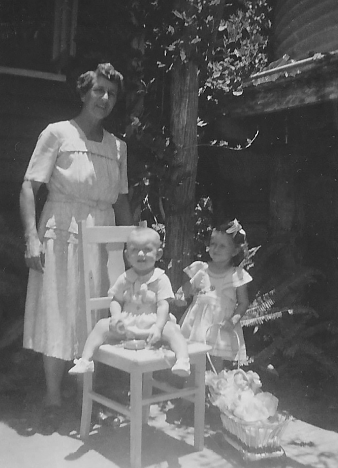 Marie with Lorraine and Ross, beside the rainwater tank.