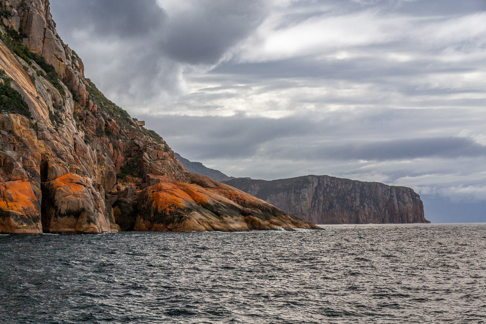 Moody sky forms a perfect backdrop to the spectacularly coloured rugged coastline on the ocean side of the Freycinet Peninsula.
