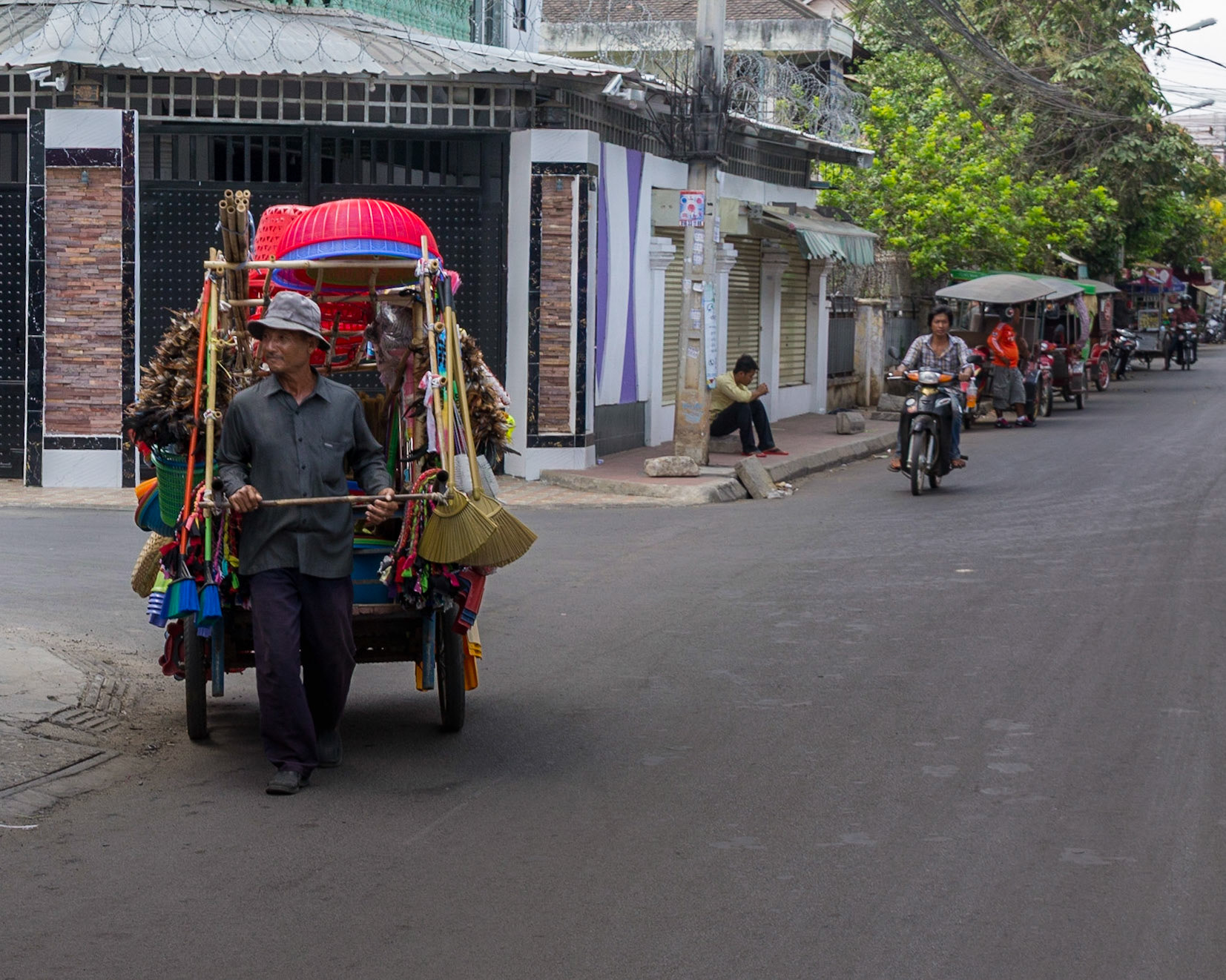 Life goes on, a street vendor wheels his goods through the streets in search of customers.