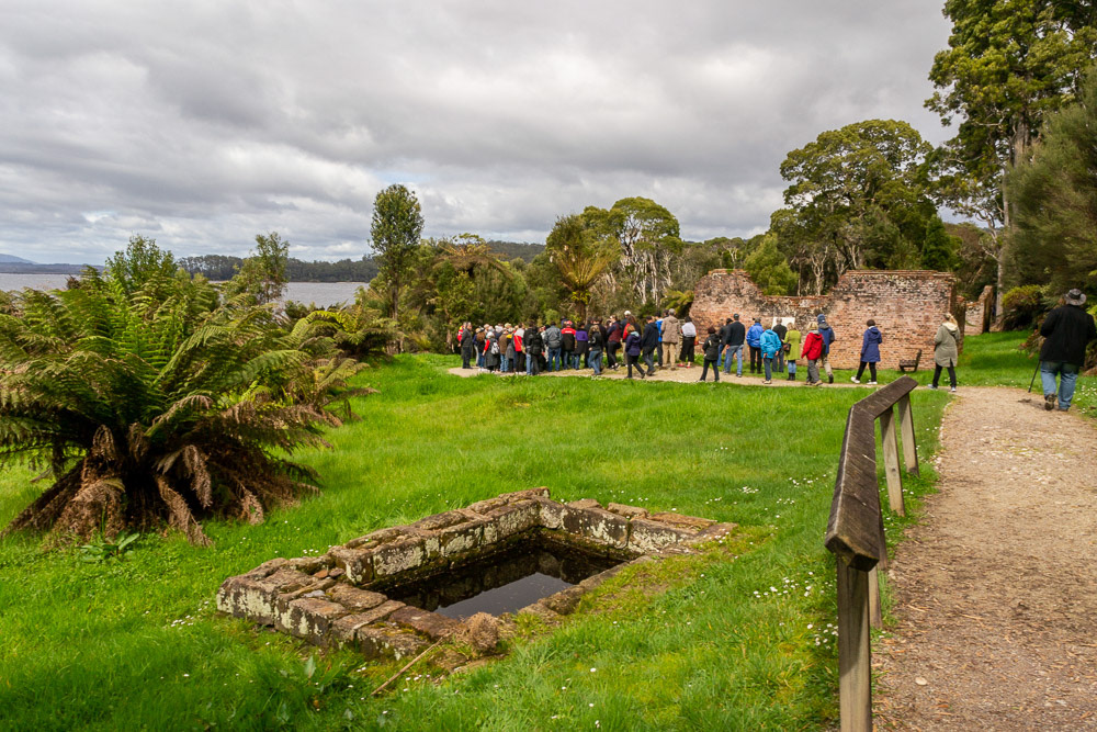 A tour group gathers beside one of the more substantial ruins of the early convict days.