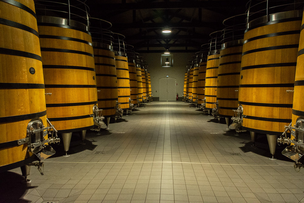 Gigantic oak barrels inside Le Chateau Gaurud-Larose wine cellars.