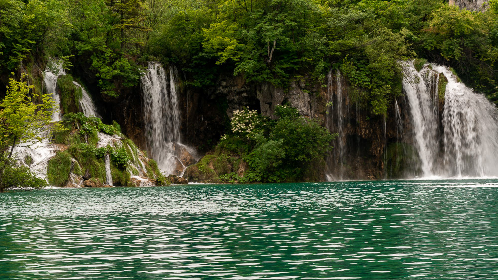 Cascades between the lush vegetation surrounding the lakes.