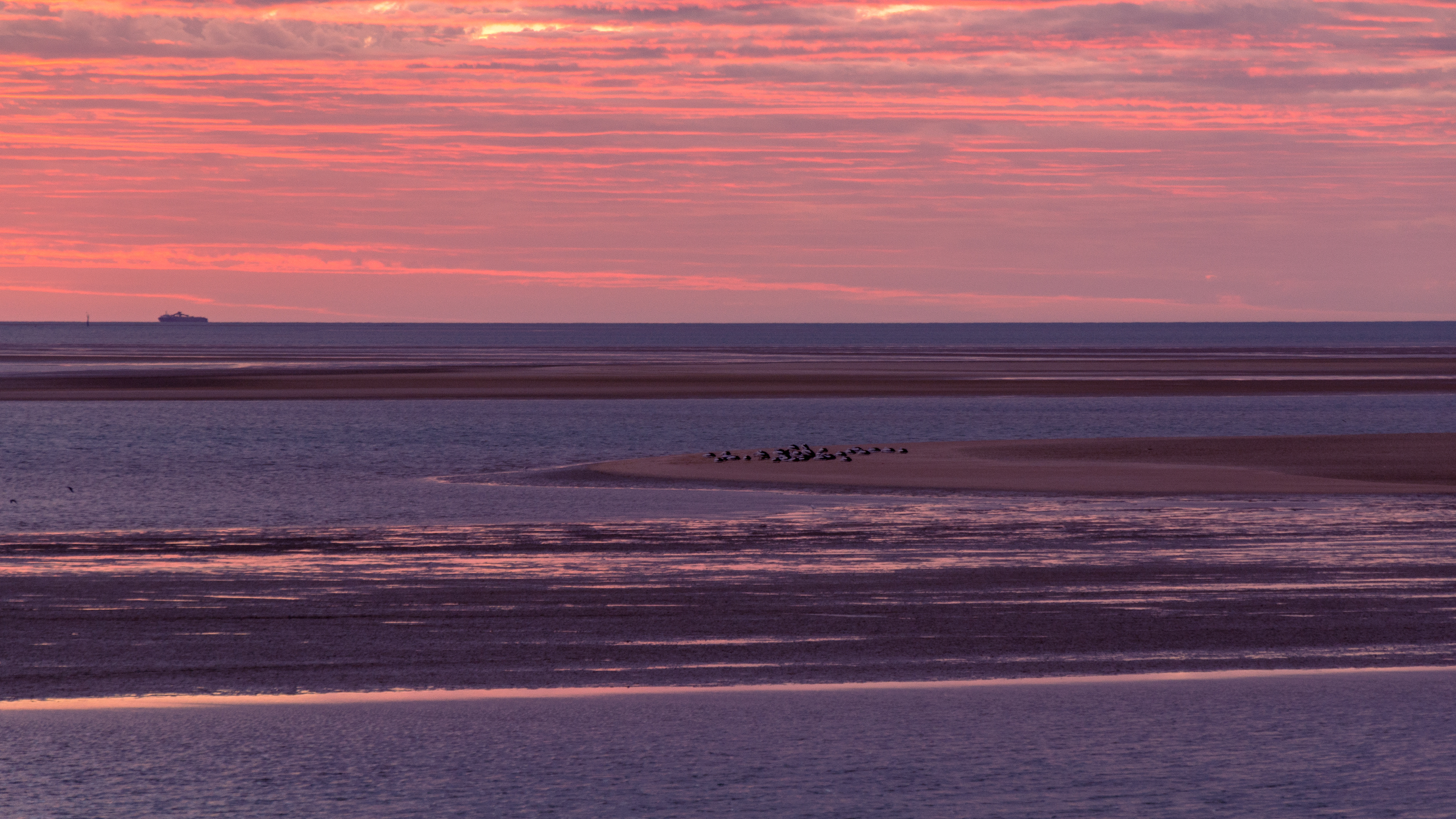 Pink highlights the clouds as the sun sets beyond the shipping channel at Karumba.