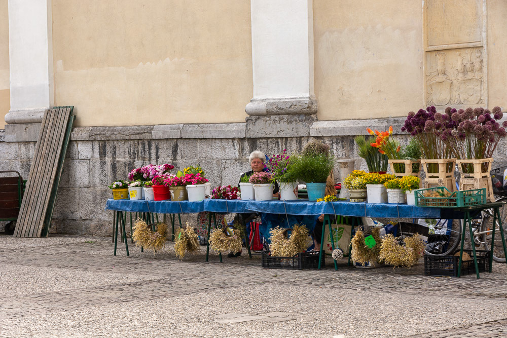 A local woman waits paitently at her flower stall for customers.