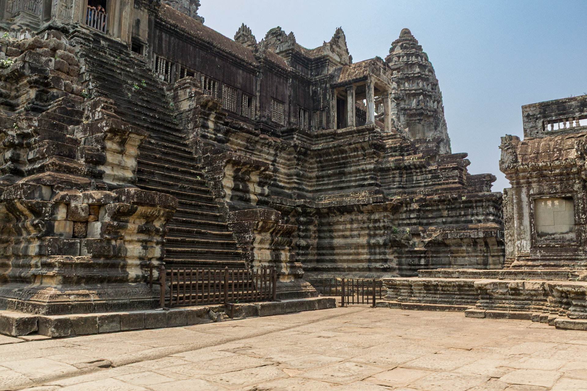 From a distance Angkor Wat appears to be a colossal mass of stone on one level but close up it is a series of elevated towers, covered galleries, chambers, porches and courtyards on different levels linked by stairways.